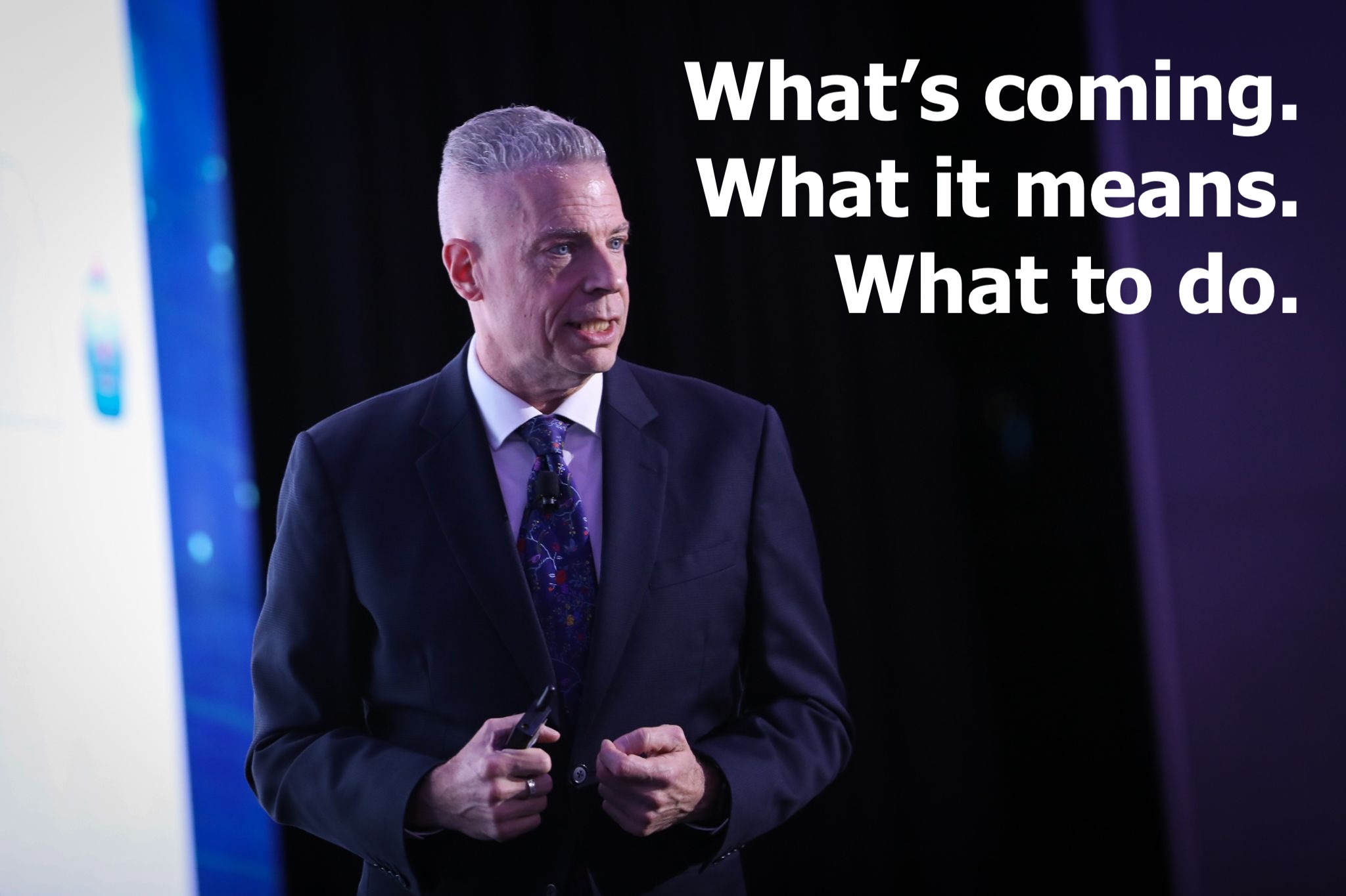 Mark Pesce speaking beside a screen reading What's coming. What it means. What to do.