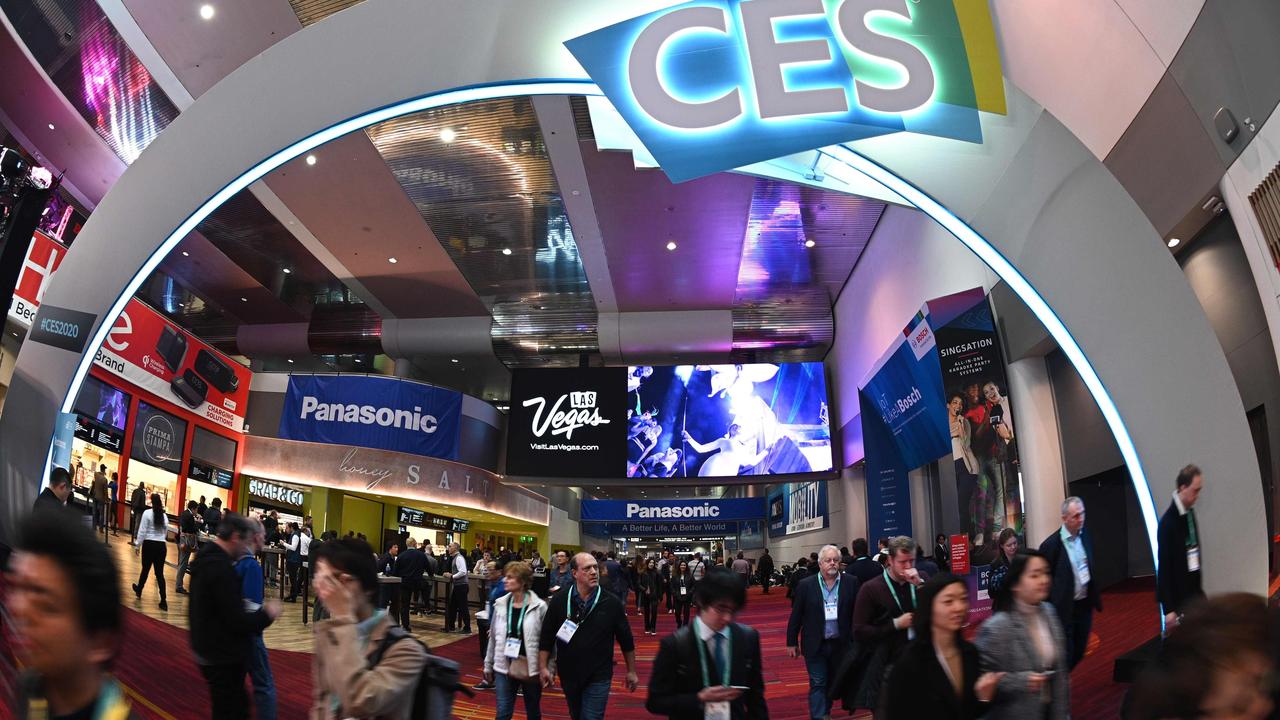 Crowds entering the CES show floor beneath an illuminated CES sign